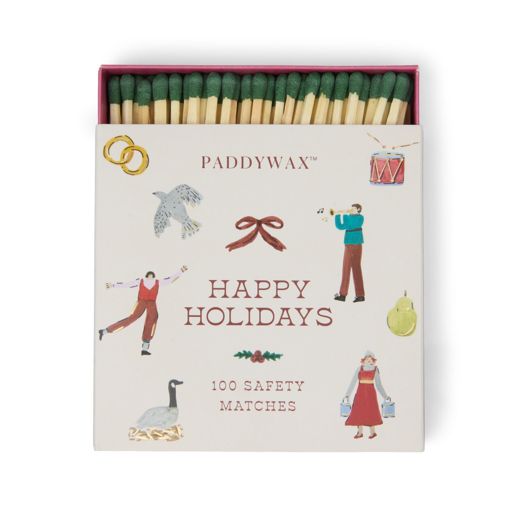 Matches in a Paddywax box with holiday illustrations on a white background