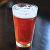 Glass of beer with a map engraving on a dark background